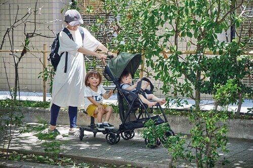 ベビーカーにベビーステップをつけてきょうだいとお出かけしているママ