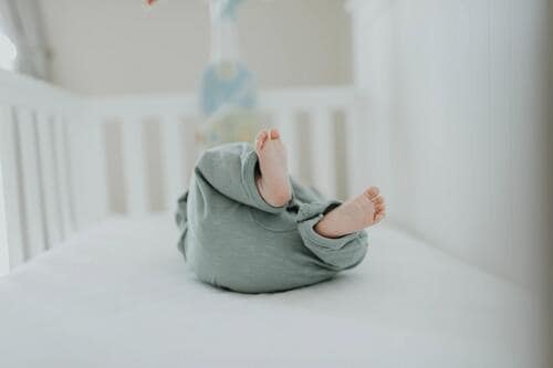 ベビーベッドに寝転がる赤ちゃん