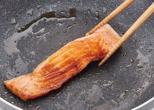 冷凍した鮭をフライパンで焼いている様子の画像