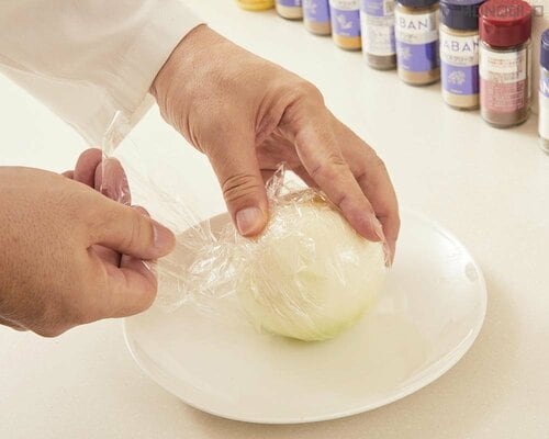 2：玉ねぎをまるごとのまま軽く水洗いして、ラップで包む 炒め玉ねぎおすすめ イメージ