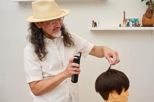 美容師がヘアスプレーの検証をする様子