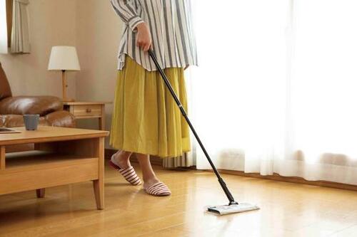 フローリングワイパーで掃除する女性の画像