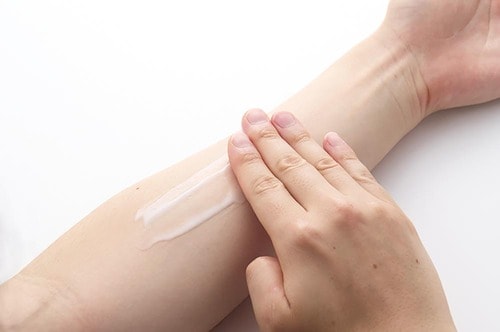 腕にボディクリームを塗る様子