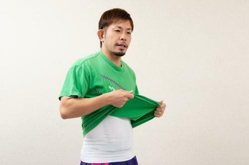 加圧シャツの上にTシャツを着用するトレーナーの板谷一樹さん