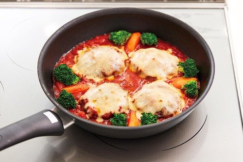 フライパンで煮込みハンバーグを作っている様子