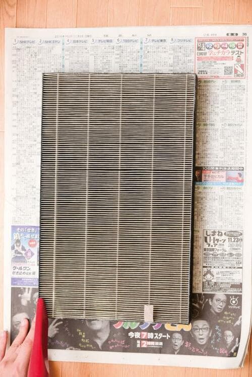 新聞紙の上にフィルターを置いたらこんな風に掃除機をかけましょう