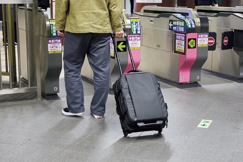駅の改札前でキュリーバッグを持つ男性の画像