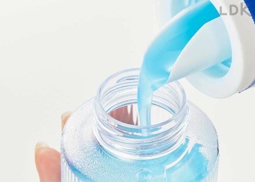 洗濯洗剤を付属のキャップに注いでいる様子