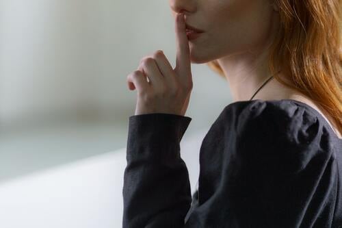 人さし指を口に当てる女性
